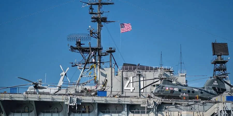 US Navy aircraft with sailors and American flag flying